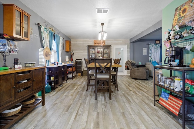 dining area featuring light hardwood / wood-style floors and a textured ceiling