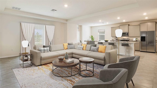 living room featuring sink and light tile patterned floors