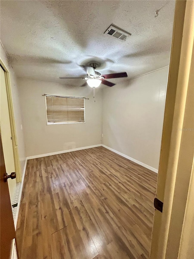 unfurnished bedroom with ceiling fan, wood-type flooring, and a textured ceiling