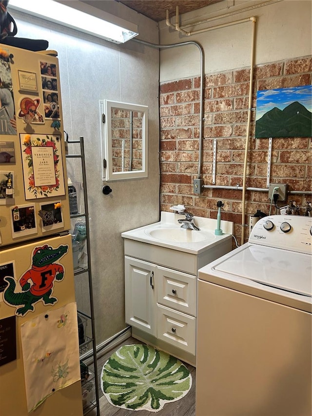 laundry area with cabinets, dark hardwood / wood-style flooring, sink, and washer / clothes dryer