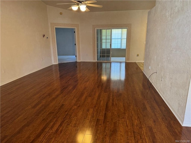 empty room featuring dark hardwood / wood-style floors, ceiling fan, and lofted ceiling