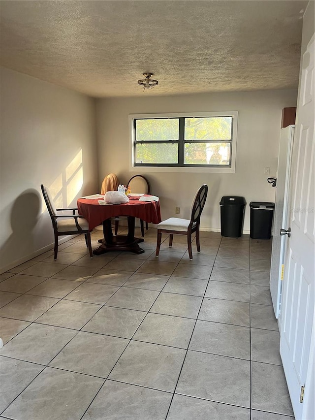 dining room with light tile patterned floors and a textured ceiling