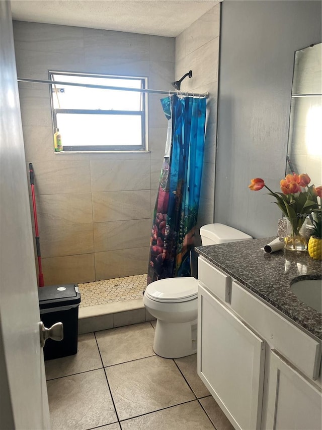 bathroom featuring tile patterned floors, vanity, toilet, and walk in shower