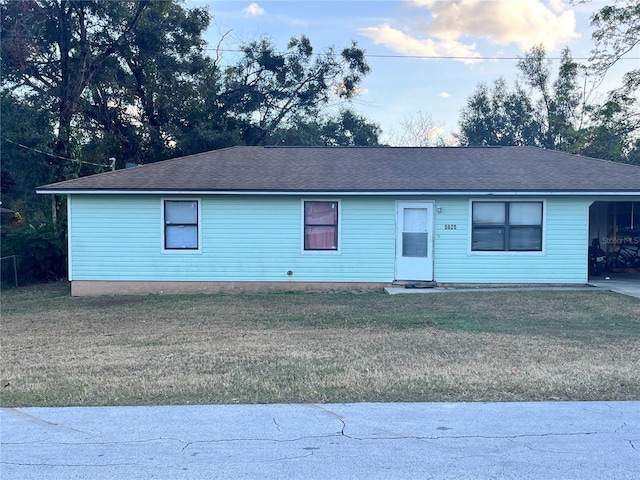 single story home with a front yard and a carport