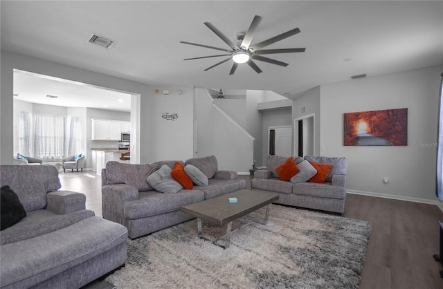 living room featuring ceiling fan and hardwood / wood-style flooring