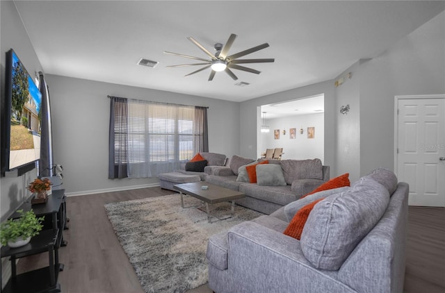 living room featuring ceiling fan and dark wood-type flooring