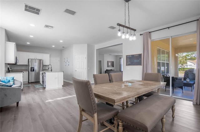 dining area with light hardwood / wood-style flooring and sink