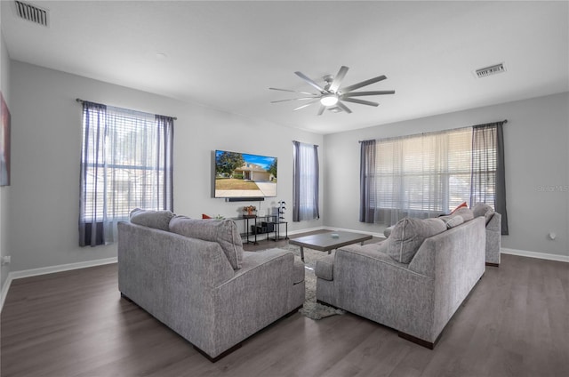 living room with a wealth of natural light, ceiling fan, and dark hardwood / wood-style floors