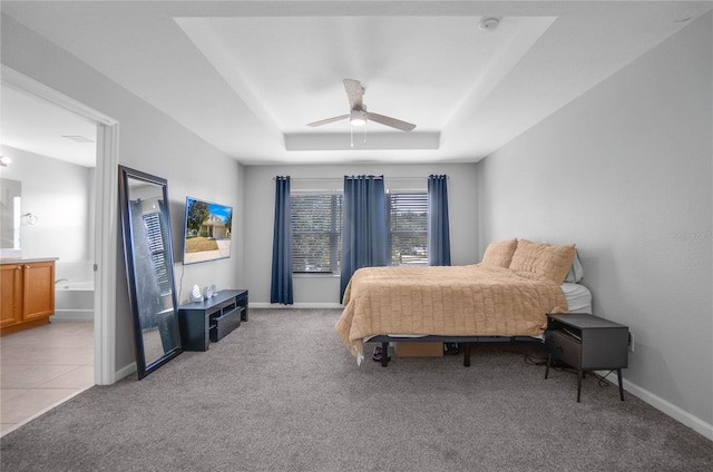 carpeted bedroom featuring ceiling fan and a raised ceiling