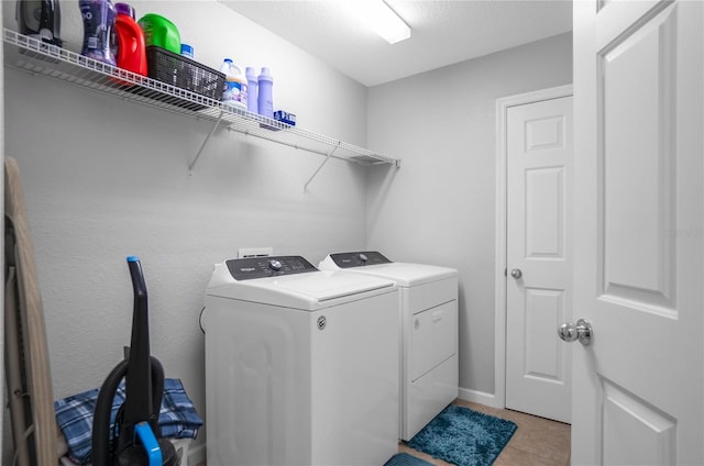 laundry room with washer and dryer and light tile patterned floors