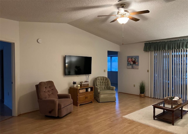 living room with a textured ceiling, ceiling fan, lofted ceiling, and light hardwood / wood-style floors