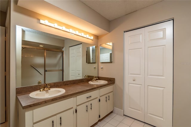 bathroom with tile patterned flooring, an enclosed shower, and vanity