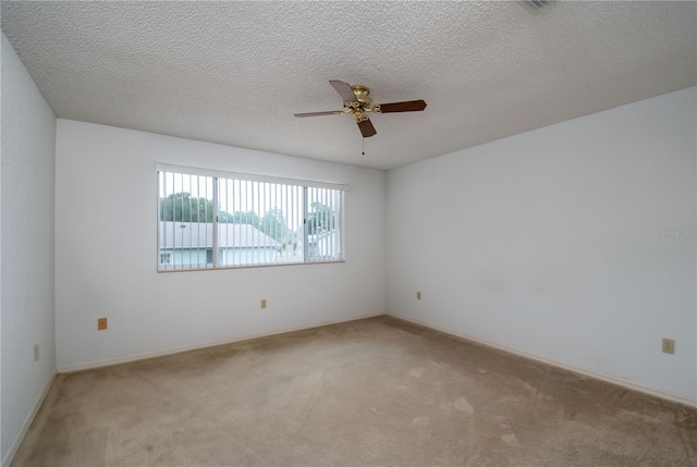 carpeted spare room featuring a textured ceiling and ceiling fan