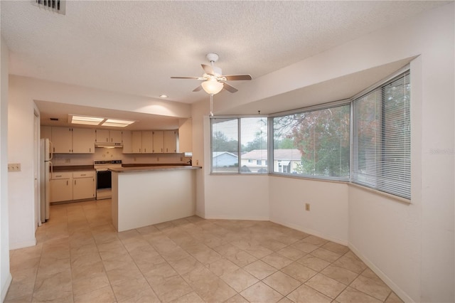 kitchen with white appliances, kitchen peninsula, light tile patterned flooring, ceiling fan, and cream cabinetry