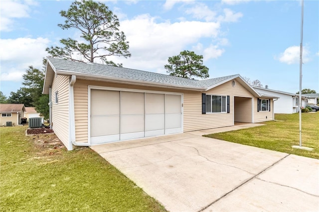 ranch-style home with a garage, cooling unit, and a front lawn