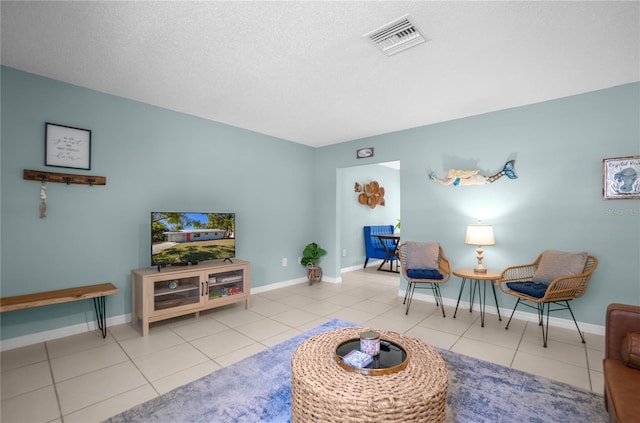 living area with light tile patterned floors and a textured ceiling