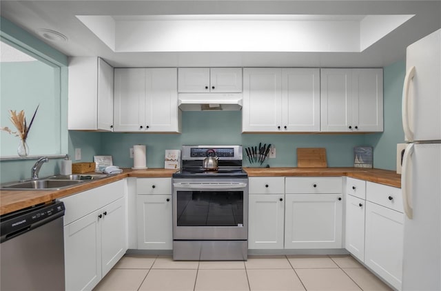 kitchen featuring white cabinets, wood counters, sink, and appliances with stainless steel finishes