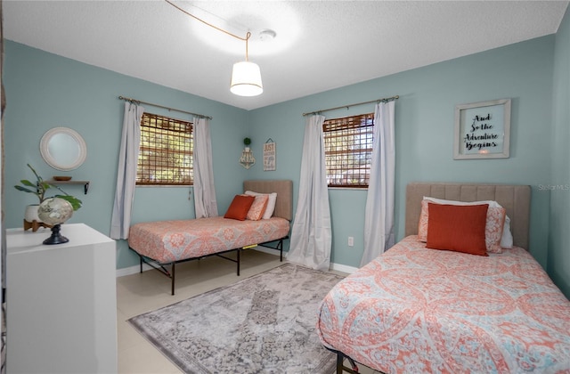 bedroom featuring multiple windows and a textured ceiling