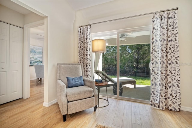 living area with ceiling fan and light hardwood / wood-style floors