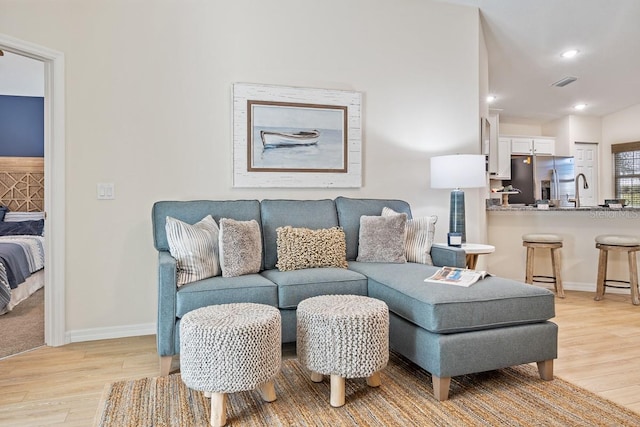 living room featuring light hardwood / wood-style floors and sink