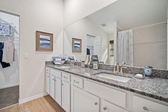 bathroom featuring curtained shower, wood-type flooring, vanity, and lofted ceiling