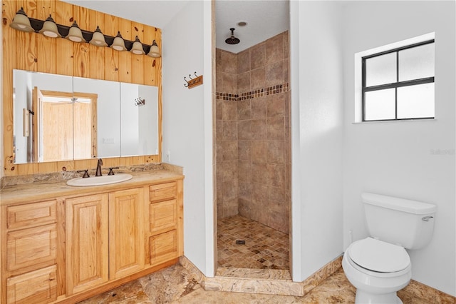 bathroom featuring vanity, toilet, and tiled shower