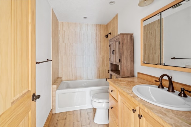 full bathroom with vanity, tiled shower / bath, and toilet