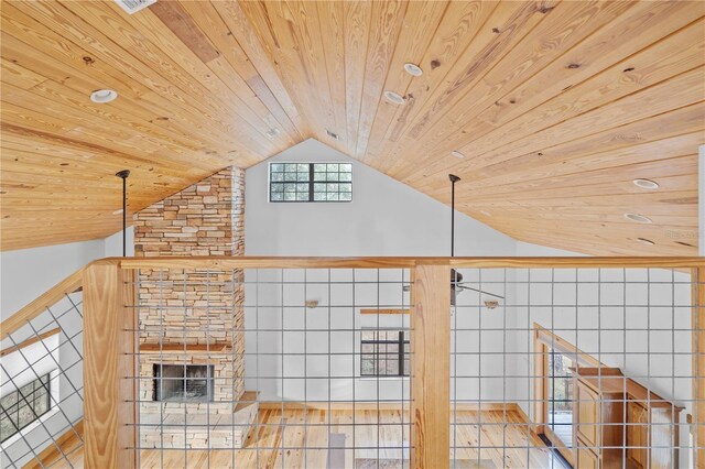 bonus room with a stone fireplace, wooden ceiling, light hardwood / wood-style flooring, and vaulted ceiling