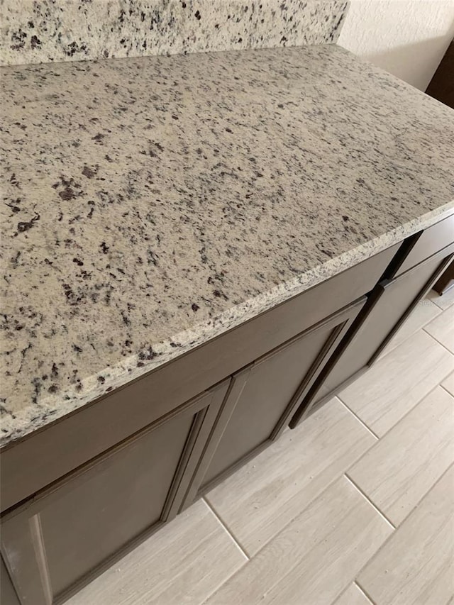 336 W Rexford Dr, Beverly Hills, FL 34465 - room details featuring gray cabinetry, light wood-type flooring, and light stone countertops