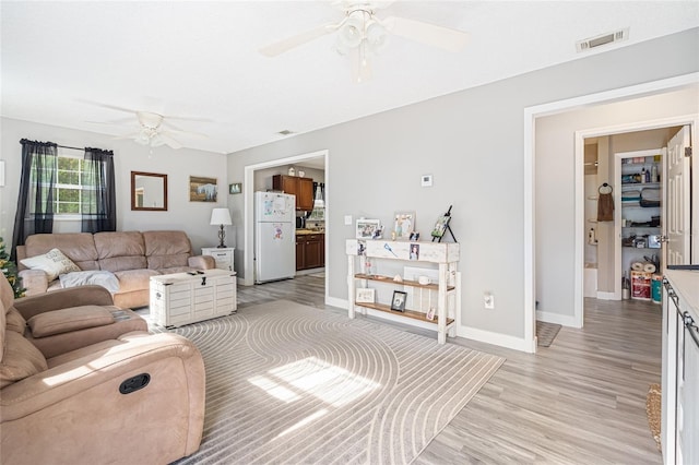 living room featuring light hardwood / wood-style floors and ceiling fan