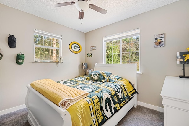 carpeted bedroom with ceiling fan and a textured ceiling