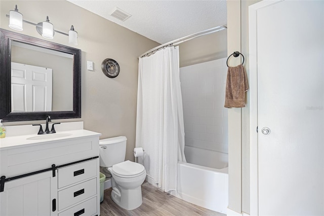 full bathroom featuring vanity, toilet, shower / bath combo with shower curtain, a textured ceiling, and wood-type flooring