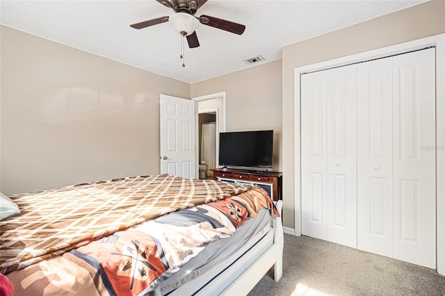 bedroom with ceiling fan, a closet, carpet, and a textured ceiling