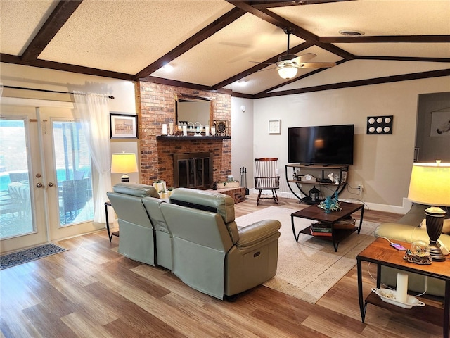 living room featuring vaulted ceiling with beams, wood-type flooring, and a textured ceiling