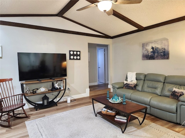 living room featuring lofted ceiling with beams, ceiling fan, wood-type flooring, and a textured ceiling