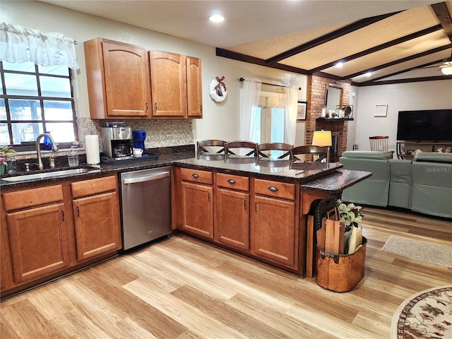 kitchen featuring decorative backsplash, stainless steel dishwasher, sink, dark stone countertops, and light hardwood / wood-style floors