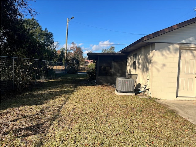 view of yard with a sunroom and central air condition unit