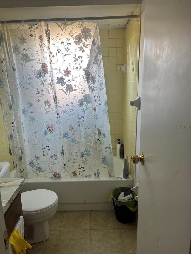 full bathroom featuring toilet, vanity, tile patterned floors, and tiled shower / bath