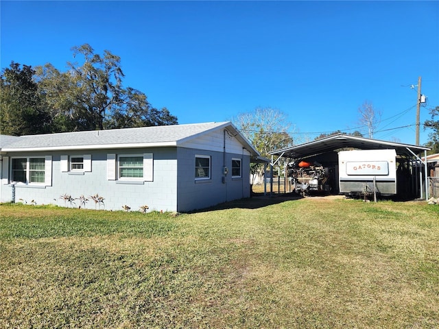 view of side of home featuring a yard and a carport