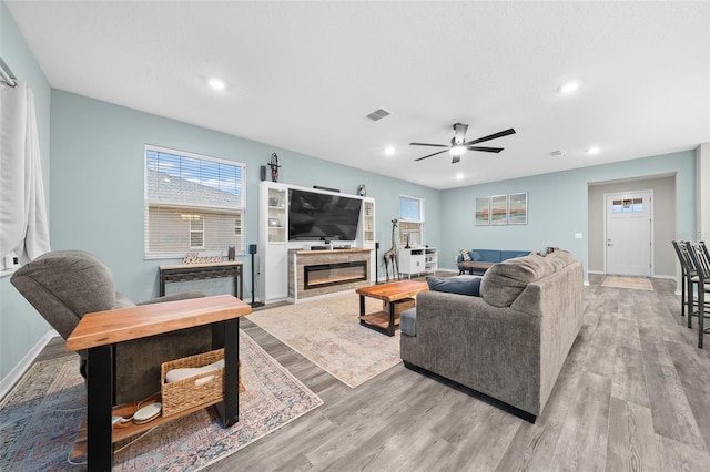 living room with ceiling fan and light hardwood / wood-style flooring