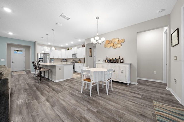 dining space with a chandelier, dark hardwood / wood-style floors, and sink