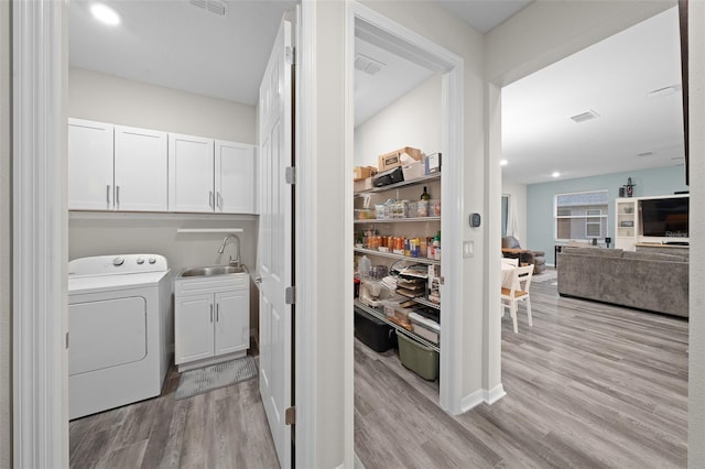 10564 SW 98th Ln, Ocala, FL 34481 - laundry room with washer / dryer, cabinet space, and light wood-style flooring