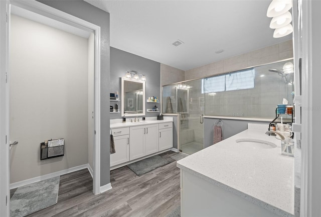 bathroom with walk in shower, vanity, and hardwood / wood-style flooring