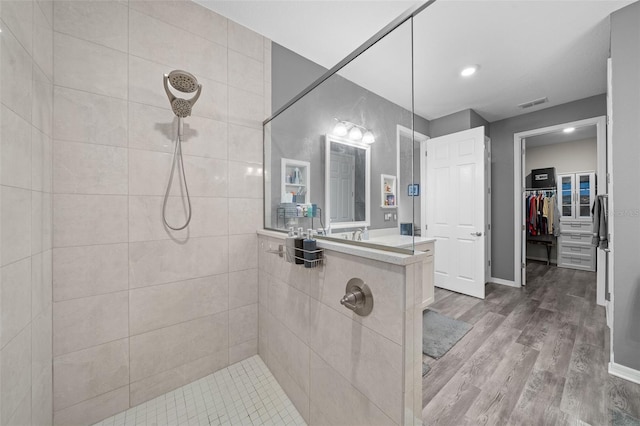 bathroom with hardwood / wood-style floors and tiled shower