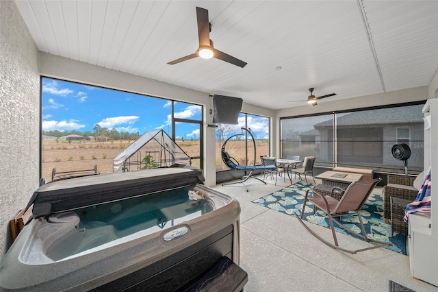 sunroom featuring ceiling fan and a hot tub