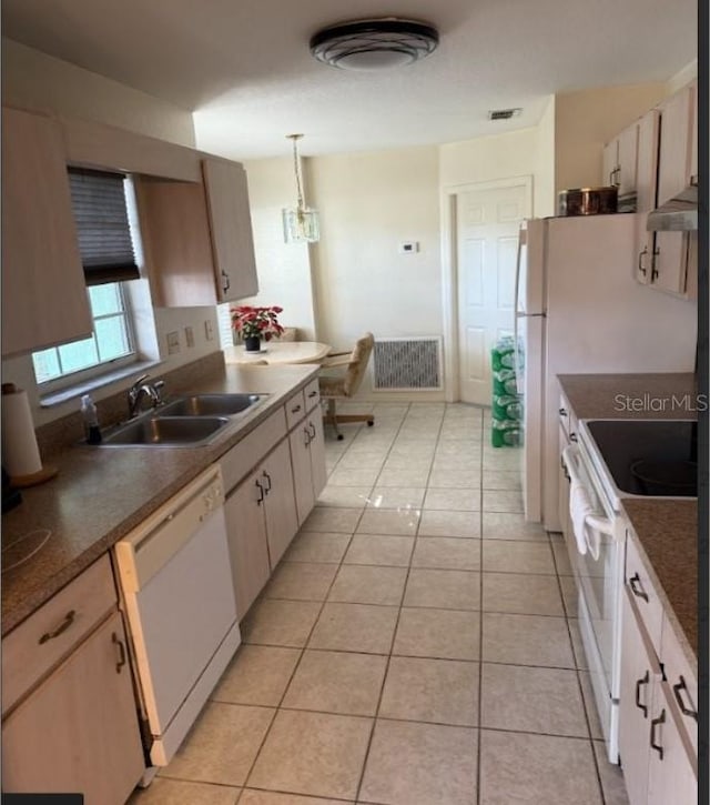 kitchen with white appliances, sink, light tile patterned floors, decorative light fixtures, and white cabinetry