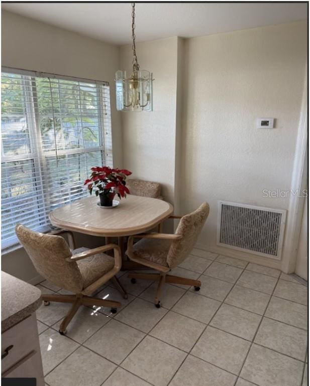 dining space featuring a notable chandelier and light tile patterned floors