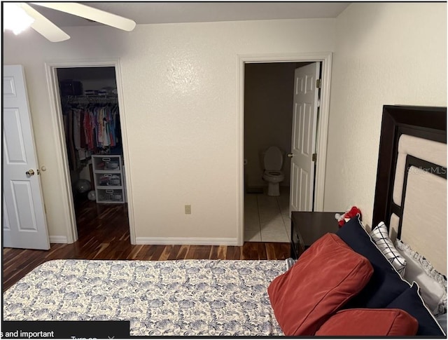 bedroom with ceiling fan, dark hardwood / wood-style flooring, ensuite bathroom, a walk in closet, and a closet