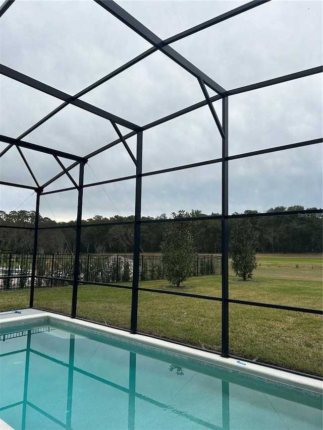 view of pool with a yard and glass enclosure