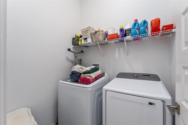 clothes washing area with washing machine and dryer